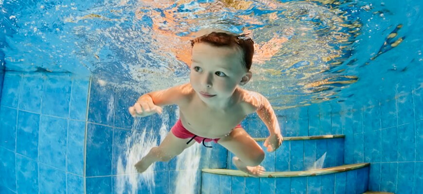 мальчик учится плавать